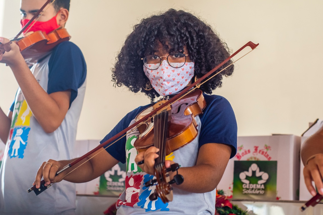 Aluna da oficina de violino durante apresentação