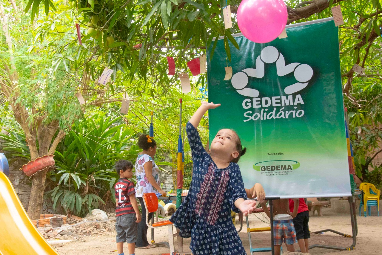 Menina faz pedido na "Árvore do Desejo" durante ação social do Gedema na Vila Conceição 